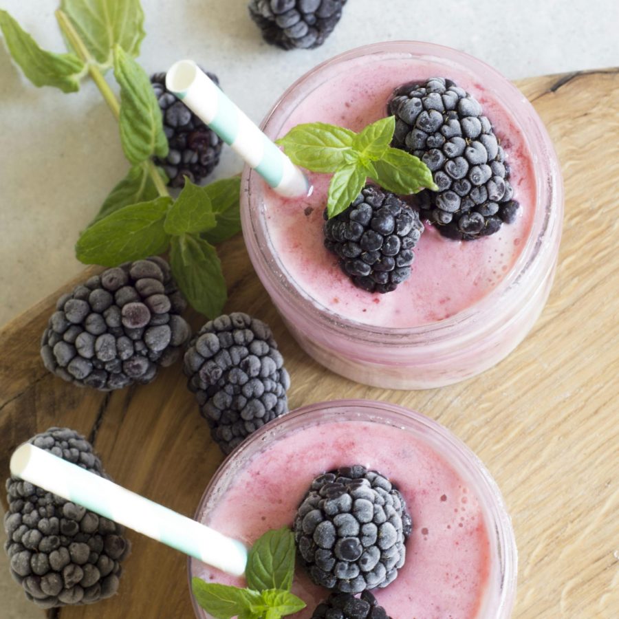 Enjoy a refreshing blackberry smoothie topped with fresh mint leaves, perfect for a summer treat.